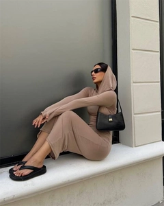 Outdoor street style view of a beige hooded long-sleeve slim-fit dress with a black shoulder bag