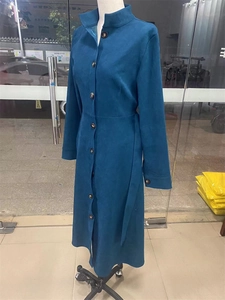 Détail du manteau en faux daim avec boutons simples, col montant et ceinture à la taille