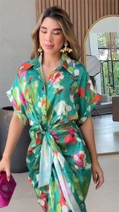 Detailed view of the green floral print dress with a waist tie and button collar