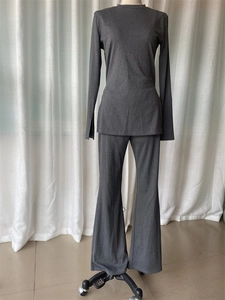Detailed view of dark grey knit set showing side slit cuffs and flare pants on mannequin