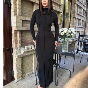 Détail de robe longue noire à manches longues avec coutures verticales et coupe ajustée