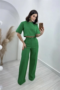 Detail of green two-piece set featuring a short crop top and high-waisted wide-leg trousers
