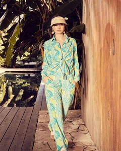 Detail of floral long sleeve shirt and wide leg trousers set in a tropical resort setting