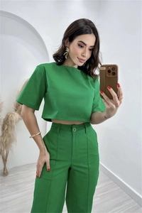 Detailed view of high-waist green linen blend pants with seam details and a crop top