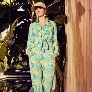 Detail of tropical palm leaf print two-piece set featuring a tie-front long sleeve shirt