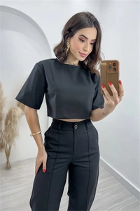 Detail of black crop top and high-waisted wide leg trousers suit with ironed pleats