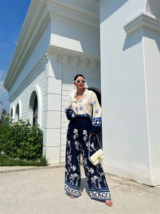 Close-up of bohemian style geometric print shirt and patterned wide-leg trousers detail
