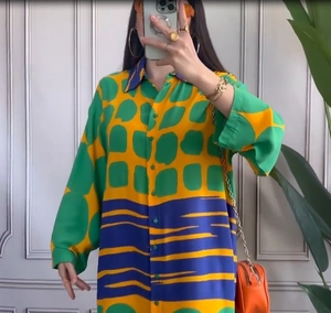 Detail view of colorful printed shirt dress with geometric patterns and button front
