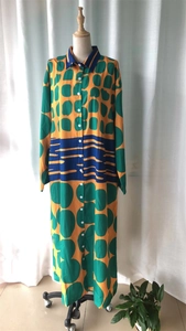 Detail of loose shirt dress with bold geometric green dots and blue striped waist