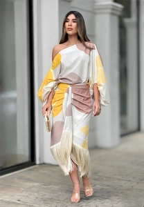 Détail de l'imprimé floral abstrait et des longues franges sur la robe à une épaule