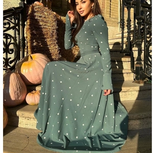 Elegante abito lungo verde scuro a fiori con maniche lunghe e cintura in ambiente autunnale