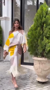 Détail du haut à manches bouffantes et jupe fluide aux motifs abstraits jaune et marron