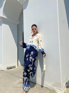 Close-up of ethnic geometric and floral print on bohemian long sleeve shirt and wide-leg pants