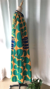 Detailed view of long sleeve maxi dress with orange geometric patterns and blue collar
