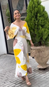 Dettaglio di un elegante maxi abito con scollo a V e stampa geometrica gialla