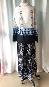Detailed view of bohemian geometric print on long sleeve top and floral wide-leg trousers
