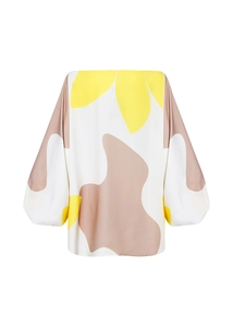 Détail de l'imprimé floral jaune et des manches lanternes sur ce haut ample pour femme
