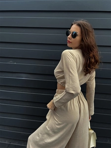 Detail von beigem Langarm-Crop-Top und High-Waist-Hose mit weitem Bein am Modell