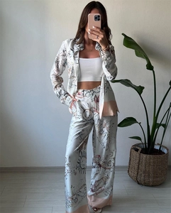 Détail d'un ensemble deux pièces en satin avec imprimés mythologiques et pantalon large