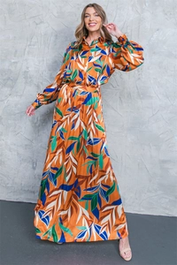 Detail of satin floral shirt and pleated maxi skirt set with vibrant leaf print patterns