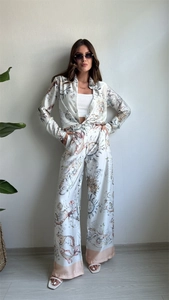 Détail de chemise en satin et pantalon large avec imprimés élégants soleil et mer