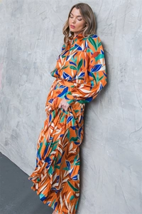 Close-up of bright orange tropical leaf print shirt dress with pleated skirt detail