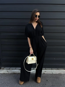 Detail of elegant black deep V-neck jumpsuit with waist tie and wide-leg silhouette