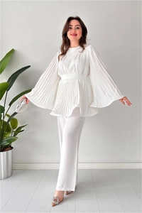 Detail of white pleated set featuring bell sleeves, elastic waist top and wide leg pants