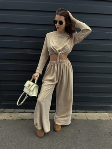 Detail von beige plissiertem Langarm-Crop-Top zum Binden und Hose mit weitem Bein