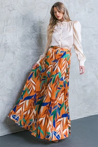 Detail of champagne satin blouse with crystal buttons and tropical pleated skirt set