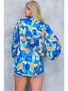 Detail of blue floral puff sleeve shirt with vibrant yellow and white patterns