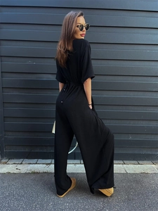 Detailed back view of a black short sleeve jumpsuit with elegant tie waist and wide leg cut