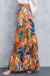 Detail of high waist pleated maxi skirt with orange and green tropical leaf print fabric