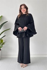 Detail of elegant black pleated two-piece set with long flare sleeves and waist tie