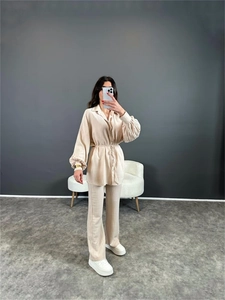 Détails du tissu gaufré beige sur chemise à manches bouffantes et pantalon à cordon