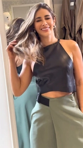 Détail du crop top licou en similicuir noir et pantalon large taille haute olive