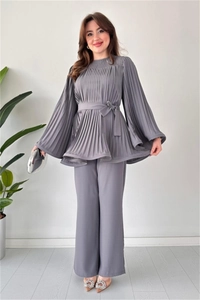 Detail of grey pleated two-piece set featuring long-sleeved tie-waist top and wide-leg pants