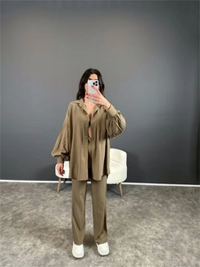 Détail d'ensemble vert olive montrant la texture plissée et la chemise à boutons