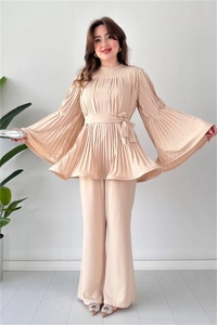 Detail of pleated champagne two-piece set featuring long-sleeve top and wide-leg trousers