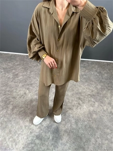 Détail du tissu froissé marron olive sur un ensemble ample chemise et pantalon fluide
