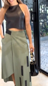 Détail d'un top dos nu pour femme et d'une jupe portefeuille olive avec patchs