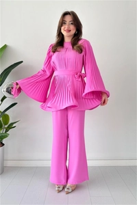 Detail of rose pink pleated set featuring flare sleeves and matching wide-leg trousers