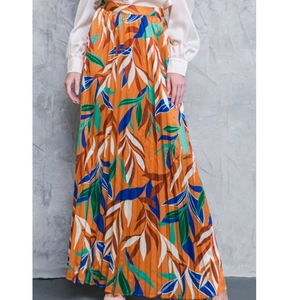 Women's pleated maxi skirt with tropical orange leaf print and flowy pleated texture