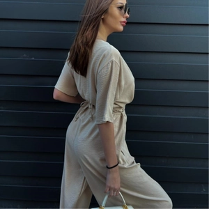 Chic beige V-neck wide-leg jumpsuit with waist tie and pleated texture for women