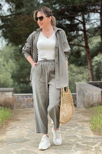 Detail of sage green loose shirt and wide-leg pants set with white v-neck vest top
