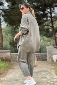Detail of olive green lounge set showing the side slit and curved hem of the shirt