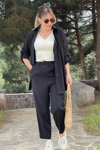Close-up of black long sleeve shirt with white V-neck ribbed vest and pearl detailing