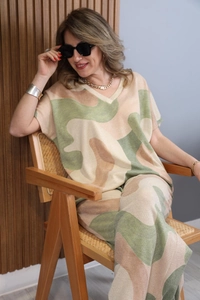 Detail of V-neck short sleeve top and trousers with marble print on a seated model