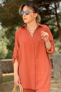 Detail of orange long-sleeved shirt with V-neckline and button-up adjustable sleeves