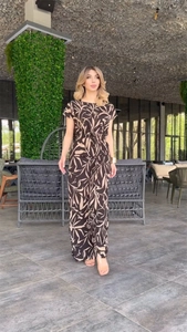 Detail of printed tie-waist top and wide-leg trousers set with tropical leaf patterns